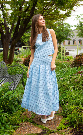 Women wearing a blue two piece skirt and top set with brown polka dots.