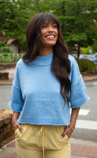 Women wearing light blue boxy sweatshirt with short sleeves. 