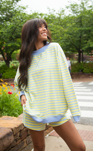 Women wearing a long sleeve and short blue and yellow striped two piece set.