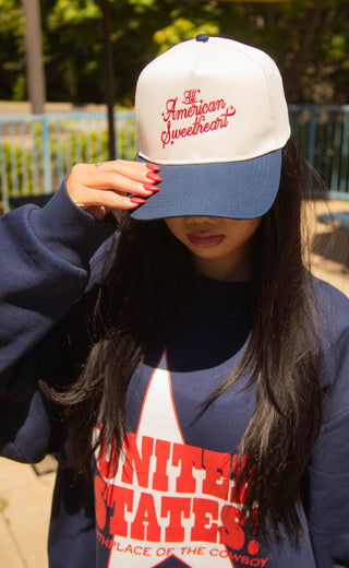 Women wearing an American Sweetheart trucker hat and sweatshirt.