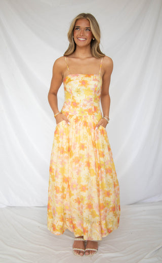 Women wearing yellow and orange floral maxi dress. 