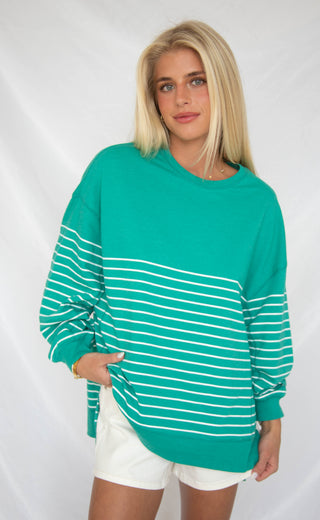 Women wearing bright green crewneck with white stripe detailing.
