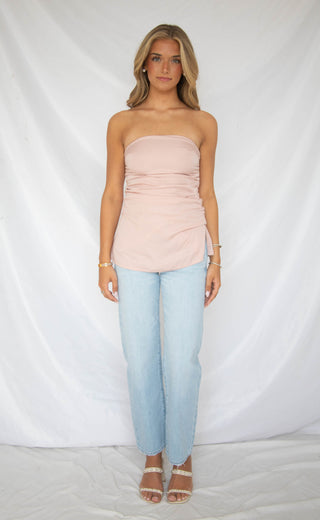 Women wearing light wash mid rise bowed straight leg jeans.