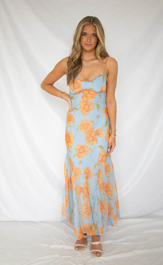 Women wearing baby blue dress with orange and green floral detailing. 