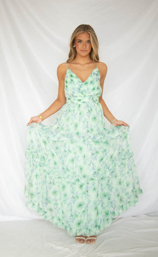 Woman wearing green and blue floral maxi dress with ruffles 