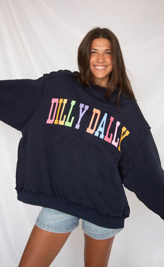 Person wearing a navy blue hoodie with 'Dilly Dally' in colorful letters on a white background