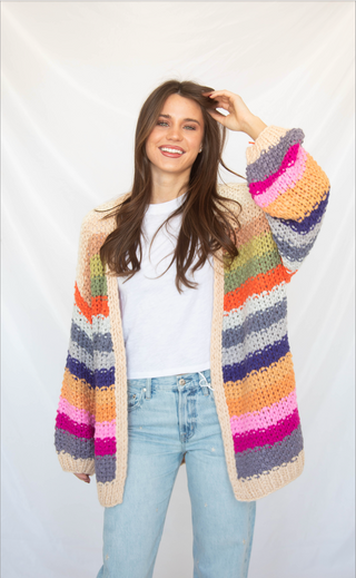 Woman wearing a colorful striped cardigan against a white background