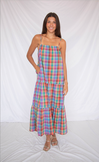 Woman wearing a colorful plaid dress against a white background